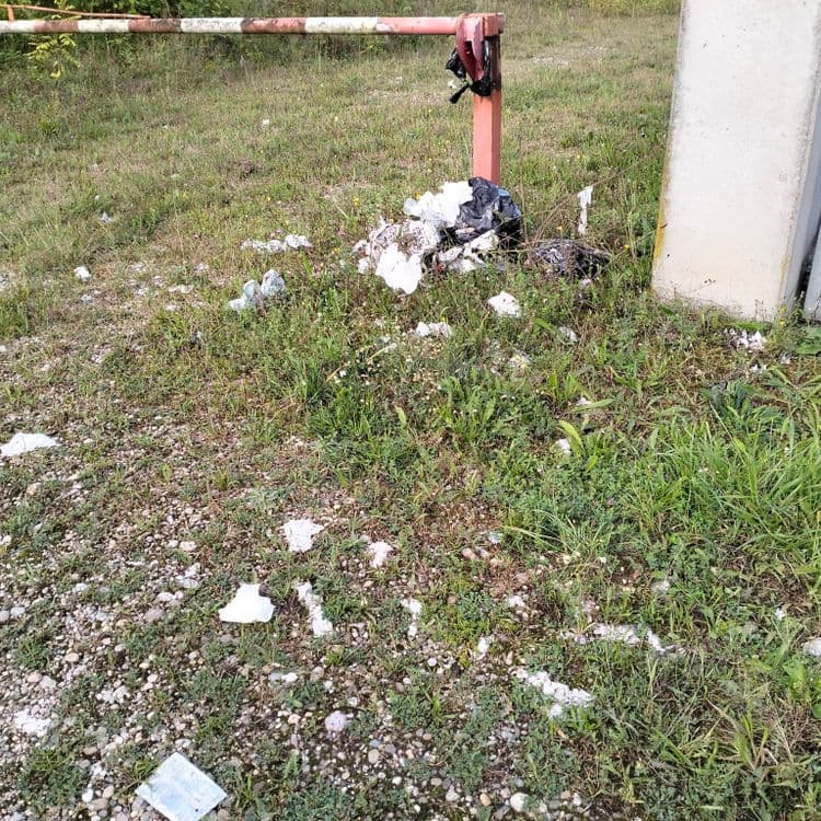 Sac poubelle éventré et déchets divers répandus aux alentours 