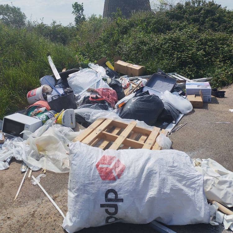 Une décharge est présente sur une piste cyclable avec des déchets de chantier mais aussi micro onde vêtement 
En face il y a des pièces de scooter et des pneus