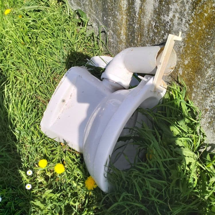 Cuvette WC abandonnée sur un parking de supermarché 