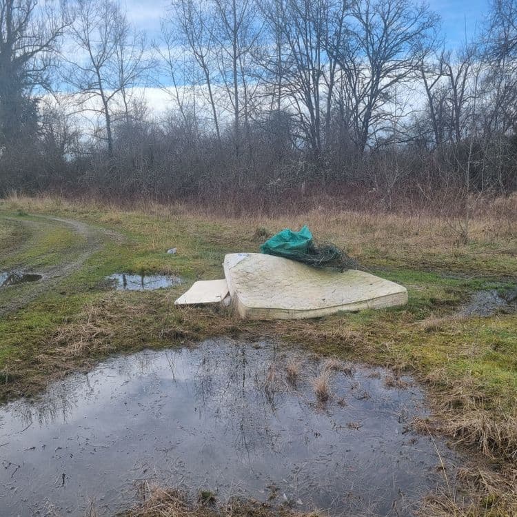 Matelas et bâche avec déchets en bois un peu plus loin