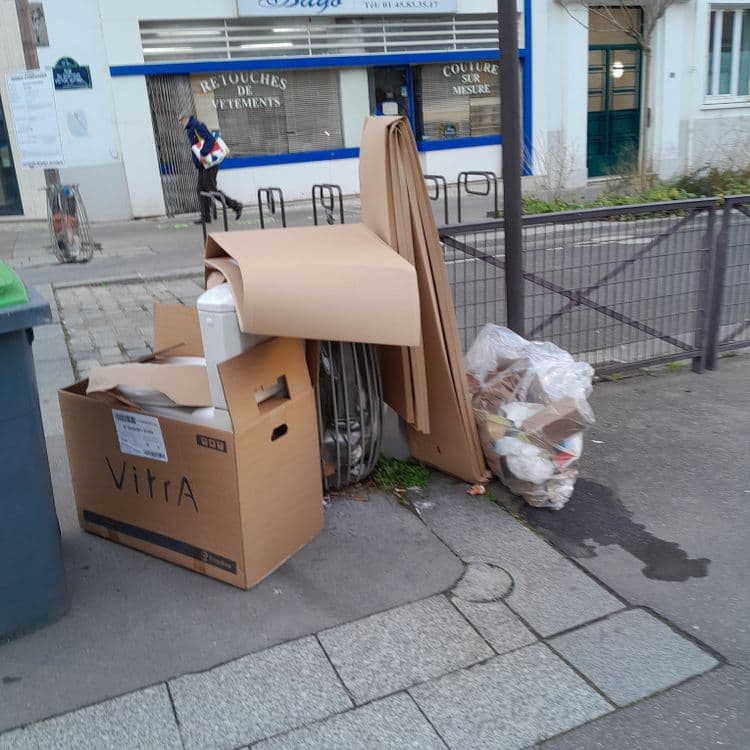 Il y a des cartons des toilettes et un sachet plastique rempli de déchets 