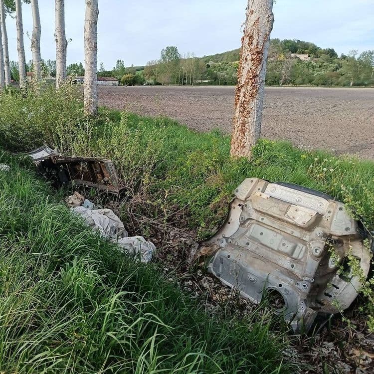 Carcasse de voiture et détritus dans le fossé 
