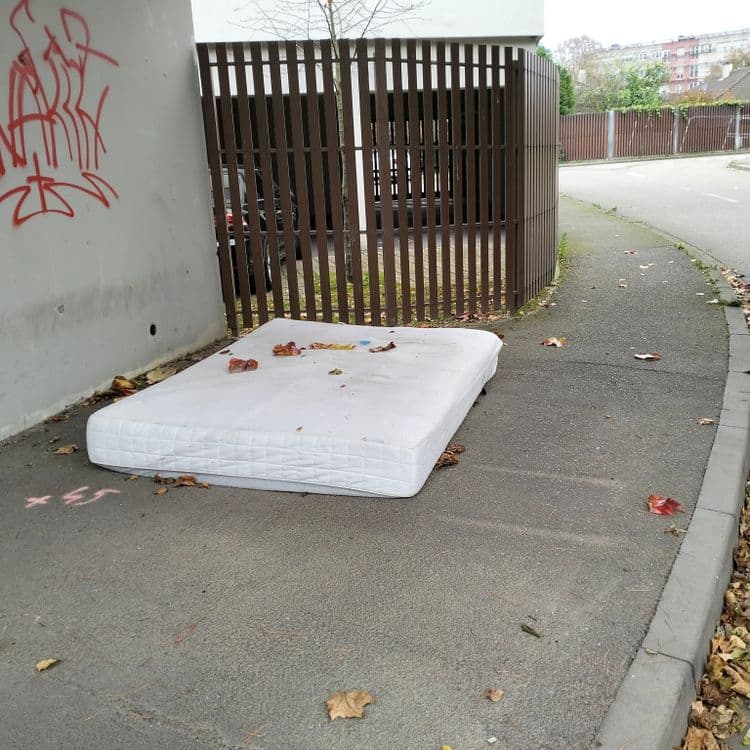 Un vieux matelas abandonné sur le trottoir sous un pont 