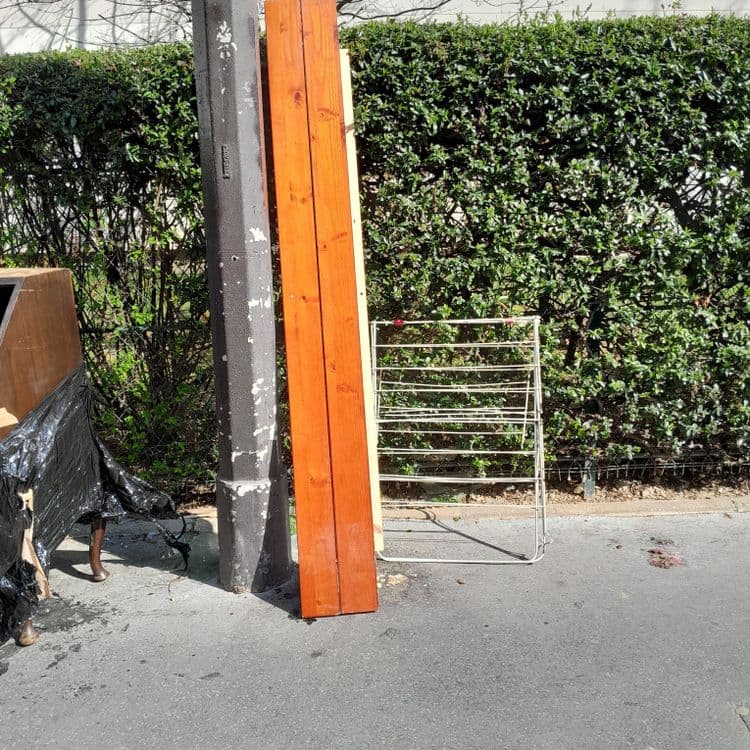 Meuble ,plache en bois ,étendoir et u. Carton rempli de sac poubelle. 
Derrière le poto il y a du verre brisé 