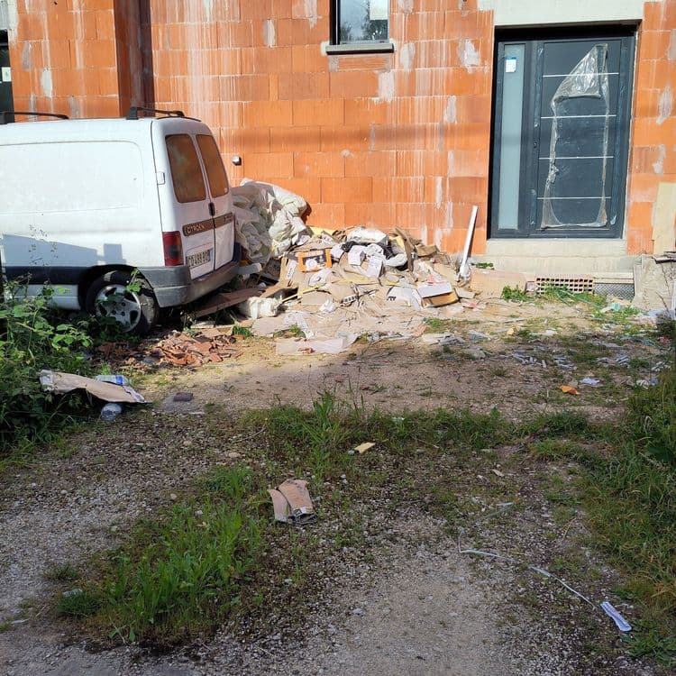 Analyse des déchets présents sur l'image :

On observe une accumulation de déchets de construction et d'emballages. Principalement, il y a du carton (environ 5 kg) provenant d'emballages divers, des sacs de chantier (environ 10 kg) contenant probablement des restes de matériaux, des chutes de tuiles ou de briques (environ 8 kg), divers plastiques d'emballage (environ 2 kg), et quelques bouteilles en plastique (environ 0.5 kg), ainsi que divers autres déchets divers liés à la construction (environ 3 kg).
