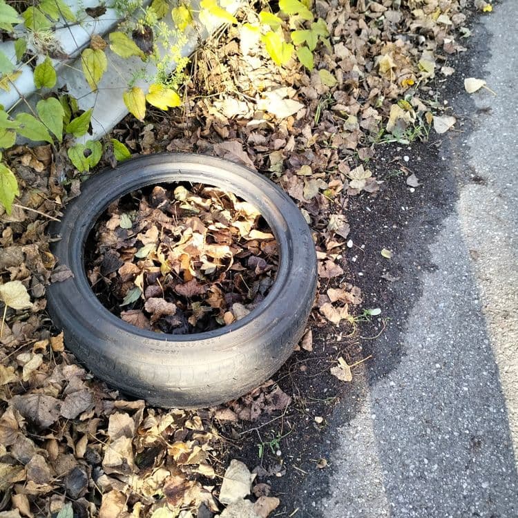 Un pneu usagé abandonné à côté d'un parking de stade 