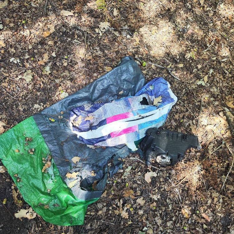 Les déchets abandonnés sont les suivants :

*   Une bâche plastique de couleur verte, estimée à 1 kilogramme.
*   Une bâche plastique de couleur gris foncé ou noire, estimée à 1,5 kilogramme.
*   Un grand sac en plastique imprimé (bleu, blanc, rose), une unité, estimée à 0,2 kilogramme.
*   Une pièce automobile en plastique de couleur noire, une unité, estimée à 1 kilogramme.