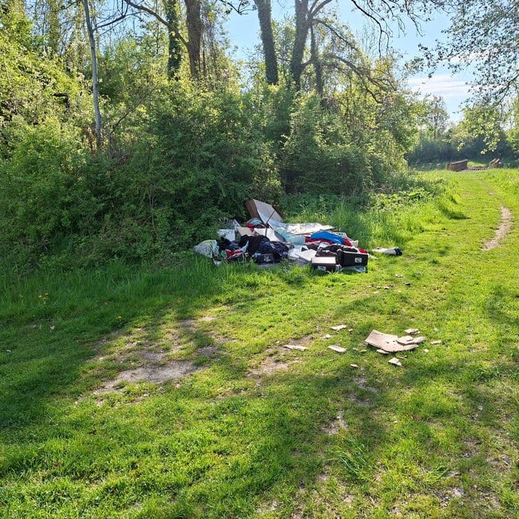 Voici une estimation des déchets présents sur l'image :

*   **Déchets ménagers en sacs plastiques** :  Quantité estimée à 5 sacs. Poids total estimé : 15 kg
*   **Cartons** :  Quantité estimée à 10 morceaux. Poids total estimé : 2 kg.
*   **Matelas** : Quantité : 1. Poids estimé : 8kg
*   **Valise** : Quantité : 2. Poids total estimé : 4 kg.
*   **Bâche plastique** : Quantité : 1. Poids estimé : 1 kg.
*   **Divers objets** : Quantité : 5. Poids estimé : 5kg.