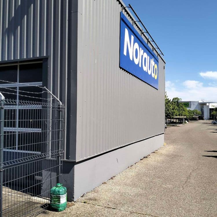 Bidon d'huile de vidange abandonné à côté d'un garage Norauto 