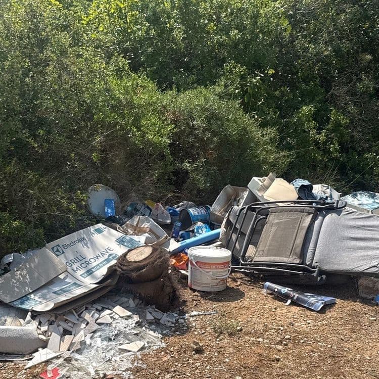 Voici le relevé des déchets présents sur le site, avec une estimation des quantités et des poids :

*   **Cartons d'emballage :** Une dizaine de cartons de tailles variées, dont des emballages d'appareils électroménagers. Poids estimé : 12 kg.
*   **Polystyrène expansé :** Une quinzaine de blocs et fragments, principalement issus d'emballages. Poids estimé : 4 kg.
*   **Mobilier rembourré :** Deux à trois sections de canapé ou fauteuil, avec des revêtements en tissu gris et vert/beige. Poids estimé : 50 kg.
*   **Structures métalliques :** Deux à trois cadres métalliques, dont un élément de transat ou de mobilier de jardin. Poids estimé : 20 kg.
*   **Textiles :** Quelques pièces de vêtements (un jean) et des chutes de tissus divers. Poids estimé : 3 kg.
*   **Plastiques divers :** Une bâche ou un tapis en plastique bleu, un seau en plastique blanc, et un ou deux bidons bleus. Poids estimé : 7 kg.
*   **Débris de chantier :** Un amas de carreaux de céramique cassés et quelques éclats de verre. Poids estimé : 12 kg.
*   **Bois :** Une souche d'arbre de taille moyenne et quelques petits morceaux de bois. Poids estimé : 25 kg.
*   **Contenant de peinture :** Un seau de peinture vide ou avec des résidus. Poids estimé : 1 kg.