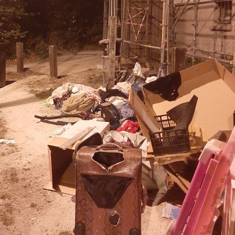 Dépôt sauvage de cartons et textiles. Peut attirer les nuisibles suite à une exposition à l'humidité (pluie)