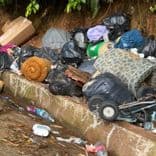Voici une estimation des déchets présents, de leur quantité et de leur poids :

*   **Sacs poubelles noirs** : On observe une quantité importante de sacs poubelles noirs, environ 20-30 sacs. Le poids estimé par sac est de 10-15 kg, soit un total de 200 à 450 kg.
*   **Matelas/Mousse** : Il y a au moins deux éléments de matelas ou de mousse enroulée. Poids estimé : 10-20 kg par élément, soit 20-40 kg au total.
*   **Mobilier rembourré (canapé/fauteuil)** : On peut identifier des parties de mobilier rembourré, possiblement un canapé ou un fauteuil démantelé. Poids estimé : 20-40 kg.
*   **Cartons** : Présence de quelques cartons, environ 2-3 unités. Poids estimé : 1-2 kg par carton, soit 2-6 kg au total.
*   **Déchets divers en plastique** : Bouteilles en plastique, emballages divers. Quantité : environ 5-10 unités. Poids estimé : 1-2 kg au total.
*   **Éléments de réfrigérateur** : Appareils de réfrigération hors service. Poids estimé 50-80kg par appareil.
*   **Autres déchets** : Présence de petits déchets épars (papiers, plastiques, etc.) difficilement quantifiables, mais pouvant représenter environ 5-10 kg supplémentaires.
*   **Objets divers** : Présence d'une poussette, de sommier. Quantité : environ 1-2 unités. Poids estimé : 10-20 kg au total.

**Poids total estimé :** Entre 538 et 1038 kg pour l'ensemble des déchets visibles. I’m