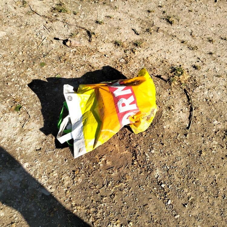 Une tente et déchets divers abandonnés sur un parking public