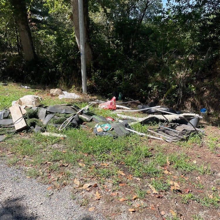 Les déchets abandonnés sur le site comprennent :
* Des revêtements de sol synthétiques, type gazon artificiel ou dalles amortissantes, en plusieurs rouleaux ou grandes sections. La quantité est estimée à environ 10 à 15 pièces, pour un poids total d'environ 100 kilogrammes.
* Des structures métalliques légères, composées de tubes et de cadres. La quantité est d'environ 10 à 12 éléments distincts, représentant un poids approximatif de 25 kilogrammes.
* Des sacs et bâches en plastique, incluant un grand sac blanc, un sac rouge, un sac noir et divers fragments. La quantité est d'environ 4 à 5 éléments principaux, pour un poids total estimé à 8 kilogrammes.
* Des pièces de bois, sous forme de planches ou de morceaux. La quantité est de 2 à 3 éléments, pesant environ 12 kilogrammes.
* Un seau en plastique. La quantité est d'un seul élément, avec un poids d'environ 1 kilogramme.