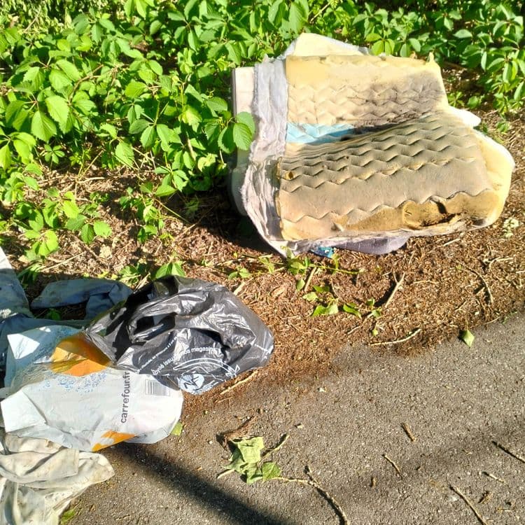 Couverture et vêtements abandonnés au bord d'une piste cyclable