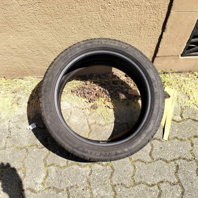 Pneu usagé abandonné sur un trottoir